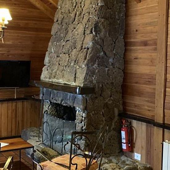 Угловой камин в облицовке камнем змеевик
