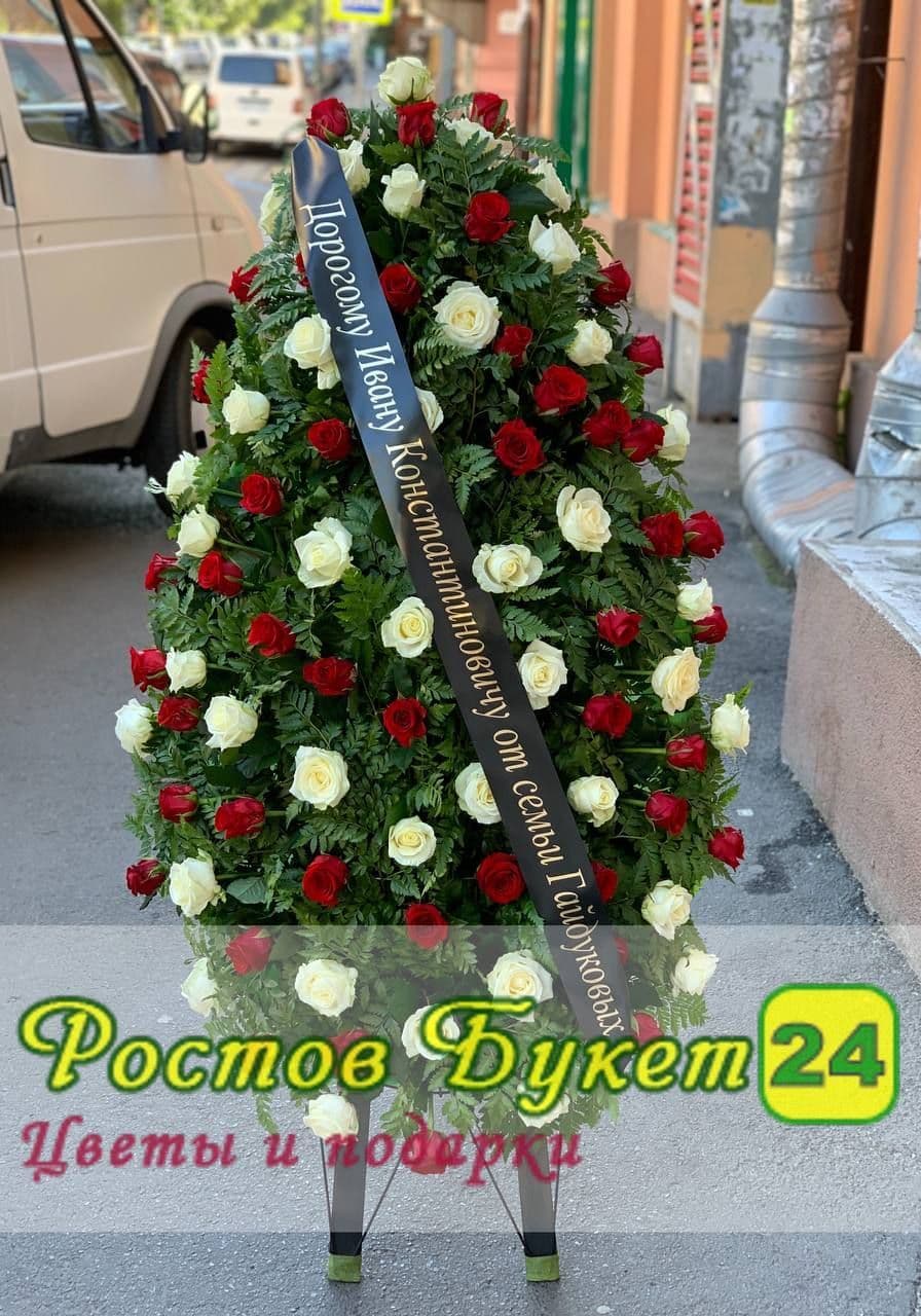 Похоронный венок из белых и красных роз.