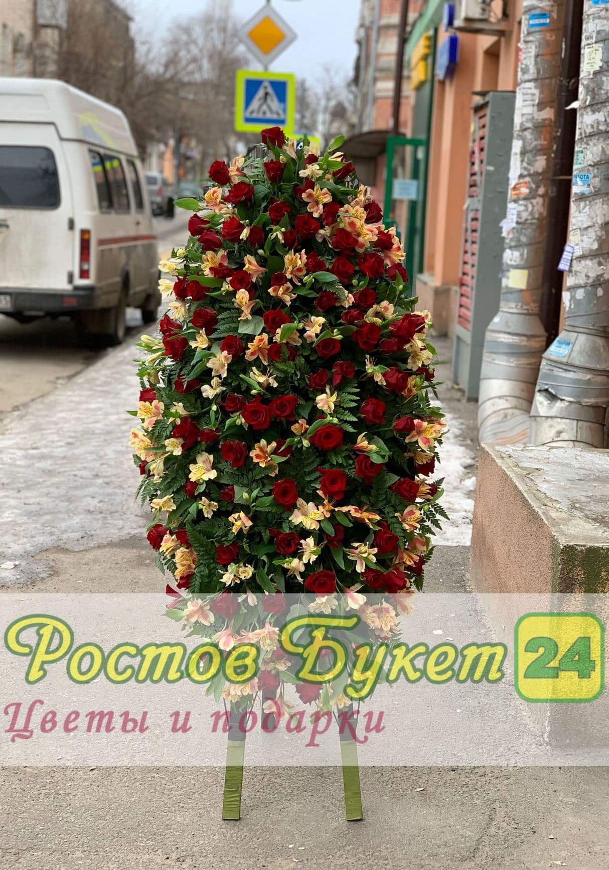Похоронный венок из белых и красных роз.