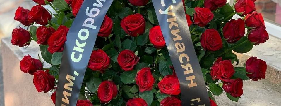 Траурная корзина из красных роз с доставкой под заказа в Ростове на Дону.